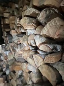 a pile of fire wood stacked on top of each other at Cisza lasu in Kadłubówka