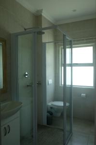 a bathroom with a toilet and a glass shower at Igoda Mouth Resort in Winterstrand +20 photos