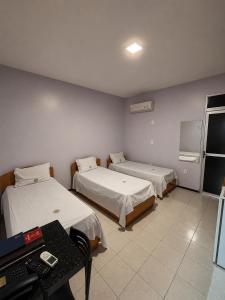 a room with two beds and a desk and a television at Pousada Planalto in Juazeiro do Norte +17 photos