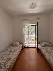 two beds in a room with a window at Apartments Vukasović in Kotor