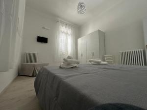 a white room with a bed with towels on it at Casa Pinuccio Sapri in Sapri