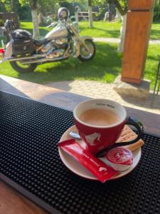 a cup of coffee on a table next to a motorcycle at Cabana Carolina in Laz