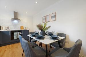 a dining room with a table with chairs and a kitchen at Charming 4BR Retreat in Hull Sleeps 8 by Stay With Us in Hull