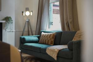 a blue couch in a living room with a window at Charming 4BR Retreat in Hull Sleeps 8 by Stay With Us in Hull