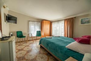a bedroom with a bed and two green chairs at Willa Tina in Karwia
