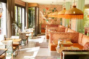 a restaurant with couches and tables and chairs at Hôtel Juana in Juan-les-Pins