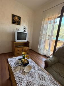 a living room with a table and a tv at Apartments Vukasović in Kotor