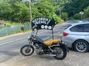 a motorcycle parked on the side of a road with a sign at Cabana Carolina in Laz