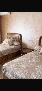 a bedroom with two beds and two night stands at تاون داون in El Dab‘a