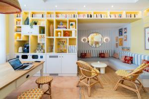 a living room with a desk and chairs and a laptop at Appartements Soléo Prado in Marseille