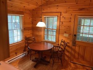 a dining room with a table and chairs in a cabin at Rivers Edge Cabins - Deer Run in Cushing +3 photos