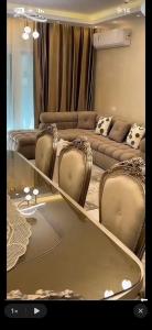 a living room with couches and a table with chairs at تاون داون in El Dab‘a