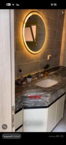 a bathroom with a sink and a mirror at تاون داون in El Dab‘a