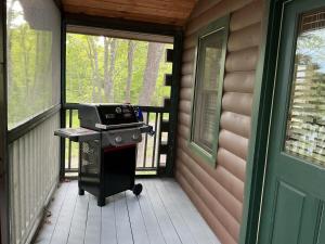 a grill on the porch of a house at Rivers Edge Cabins - Deer Run in Cushing