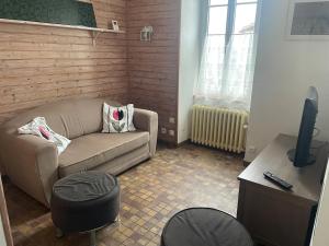 a living room with a couch and a table at Maison de Tisserand 10 pers in Gesté