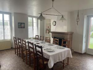 a dining room with a table with chairs and a fireplace at Maison de Tisserand 10 pers in Gesté