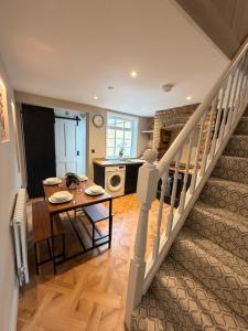 a kitchen and dining room with a table and a staircase at St Johns Central Canterbury Cottage in Canterbury