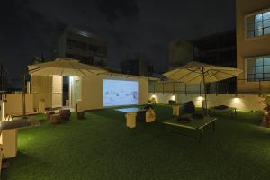 a room with two umbrellas and a projection screen at Slackpackr Malakpet Hyderabad in Hyderabad