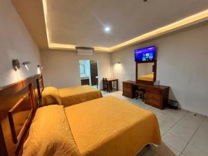 a hotel room with two beds and a flat screen tv at Hotel Santa Engracia in Ciudad Valles