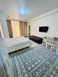 a bedroom with a bed and a table and a rug at 1apartment on First Line-Bosteri in Bosteri
