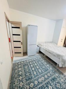 a room with a bed and a refrigerator and a rug at 1apartment on First Line-Bosteri in Bosteri
