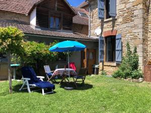 two chairs and a table with an umbrella in a yard at ROMELLA's ROOM in Saint-Projet