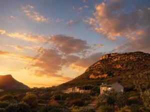 a house on a hill with a mountain in the sunset at Katkop Resort in Graafwater