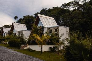 two white houses with metal roofs on a road at Boutique Amazonia Hotel Restaurante in Alter do Chao