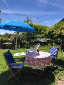a table and two chairs with a blue umbrella at ROMELLA's ROOM in Saint-Projet +4 photos