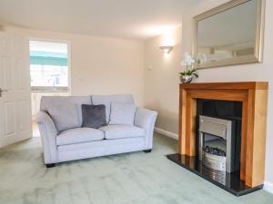 ein Wohnzimmer mit Sofa und Kamin in der Unterkunft Frome View in Wareham
