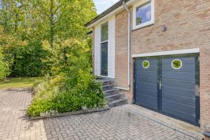 a brick house with a blue garage at Holidayhouse De Schotsman in Kamperland