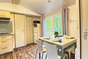 a kitchen with a table and chairs in a room at Clairière AC - Petfriendly Piscine in Saint-Chéron +12 photos