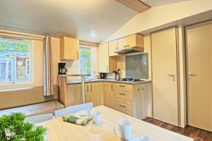 a kitchen with a wooden table and a dining room at Clairière AC - Petfriendly Piscine in Saint-Chéron