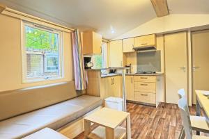 a small kitchen with a couch and a table at Clairière AC - Petfriendly Piscine in Saint-Chéron