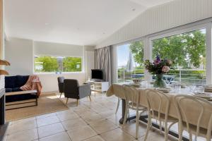 a dining room with a table and a living room at Holidayhouse De Schotsman in Kamperland