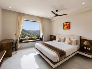 a bedroom with a large bed and a large window at Mount Valley Resort in Kumbhalgarh +47 photos