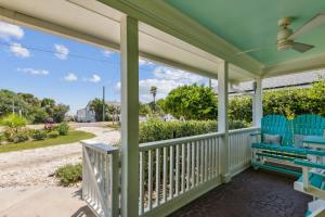 a porch with two blue chairs and a fan at 115 South Fletcher in Fernandina Beach