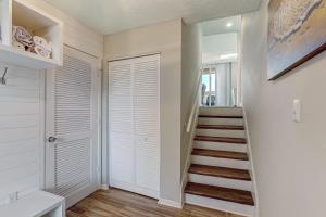 a hallway with a staircase with white walls and a white door at 1172 Beach Walker in Amelia Island