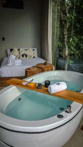 a bath tub in a room with a bed at Cabanas Rancho Alcântara in Treviso