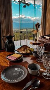a table with plates of food on a table with a window at Cabanas Rancho Alcântara in Treviso