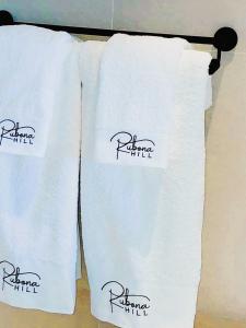 three white towels are hanging on a rack at RUBONA HILL Lodge in Gisenyi +26 photos