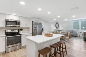 a kitchen with white cabinets and a kitchen island with stools at 1321 Shipwatch in Amelia Island +36 photos