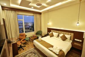 a hotel room with a bed and a window at Trillium Hotel by Stay Sphere in Srinagar +24 photos