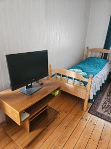 a television on a table in a room with a bed at Cousy Center House in Šiauliai