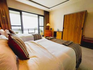 a hotel room with two beds and a large window at RUBONA HILL Lodge in Gisenyi