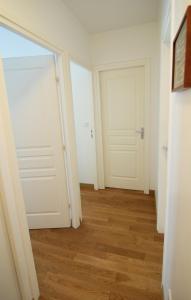 a hallway with two white doors and a wooden floor at Le Studio Rivage - Surplombant le lac in Duingt