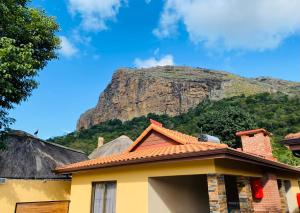 a house with a mountain in the background at N'taba River Lodge & Spa in Port St. Johns +67 photos