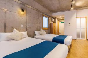two beds in a room with two beds sidx sidx sidx sidx at Kokusai Street Garden Hotel in Naha