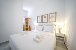 a bedroom with a white bed with towels on it at Veniro Luxury Apartments in Moírai