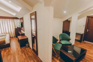a room with a green chair and a mirror at Trillium Hotel by Stay Sphere in Srinagar